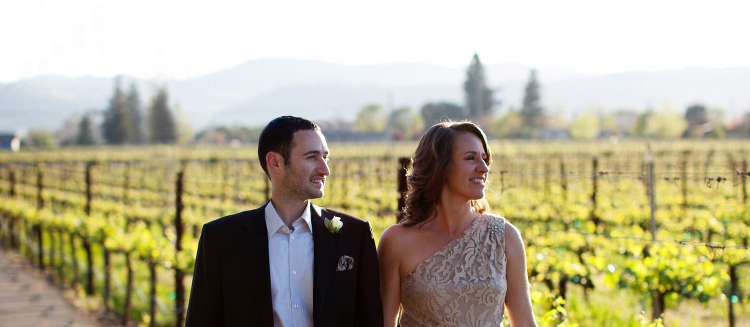 Adam and Stacy walking through the vineyard in Napa on our wedding day.